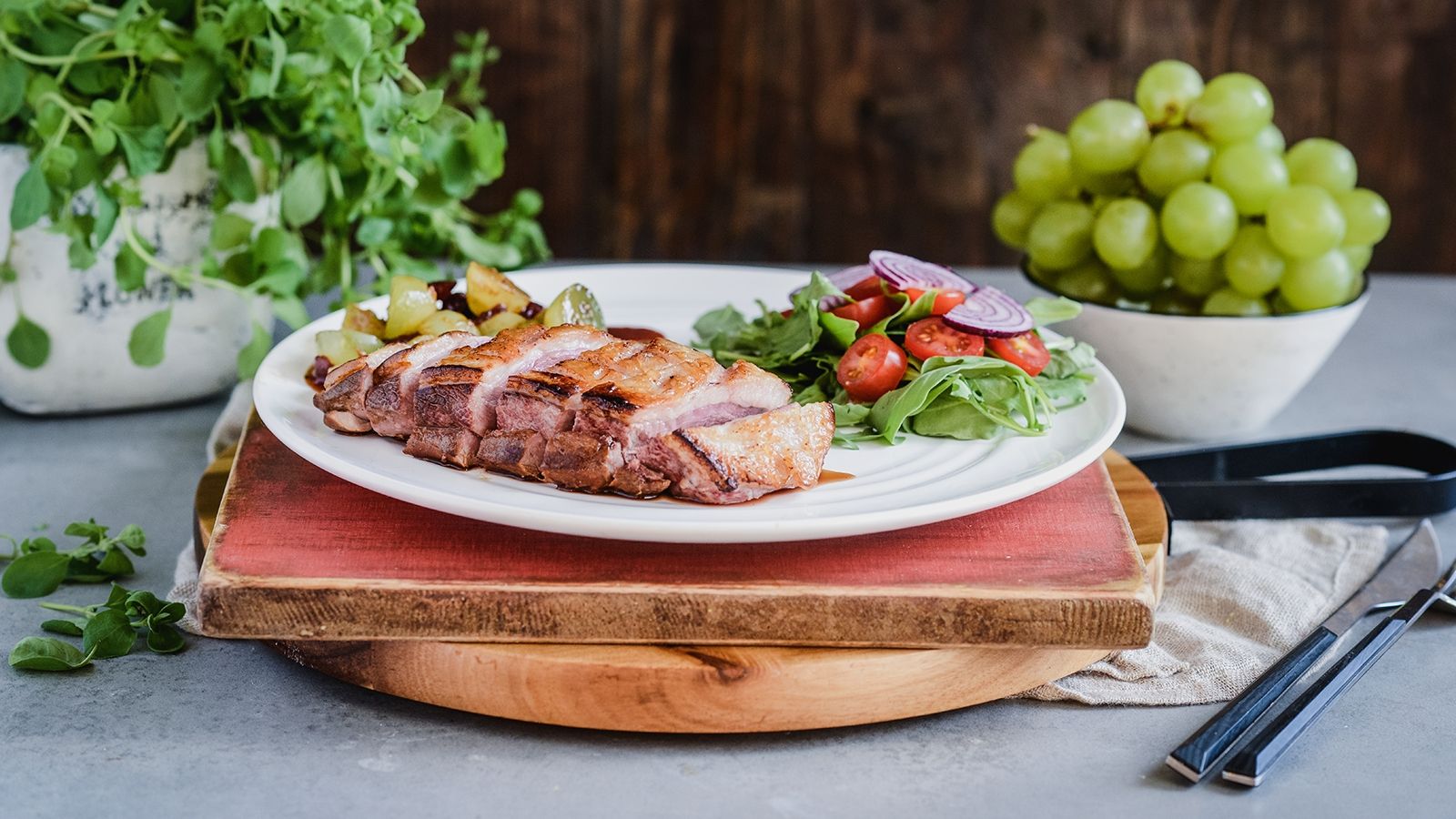 Pierś kaczki z winogronami, w marynacie sojowo-miodowej, podana z sałatką z rukoli