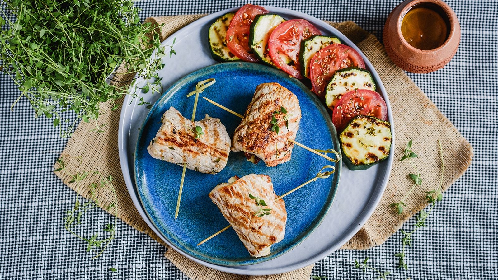 Roladki ze schabu z mozarellą podane na sałatce z grillowanej cukinii i pomidorów